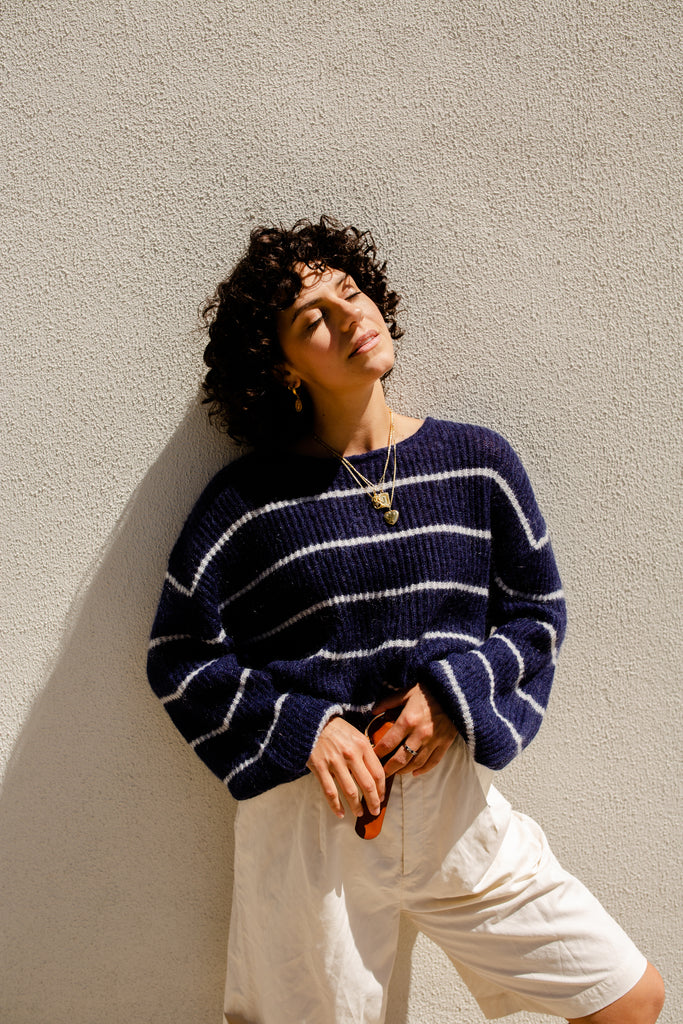 Rachel wearing our Ava stripe knit sweater in navy snow with white bermuda shorts 