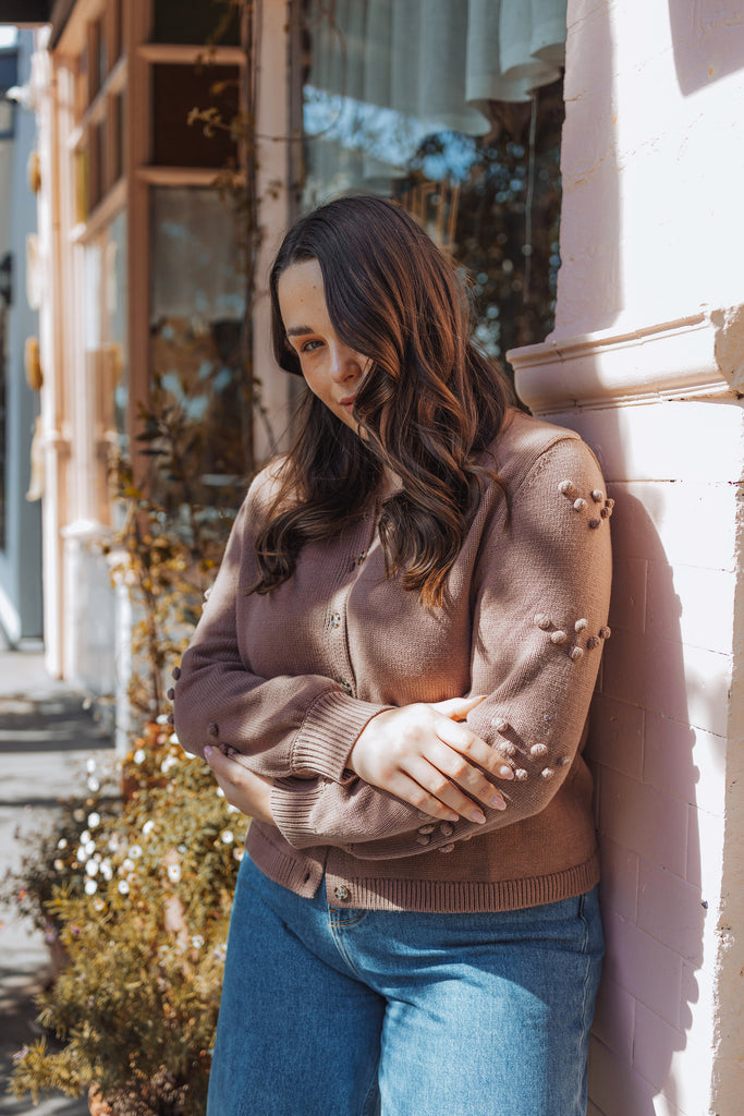 model wearing thrd label camellia cardigan in latte with henne jeans outside advieh